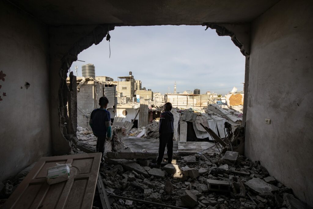 Två barn tittar ut över förödelsen i Gaza.